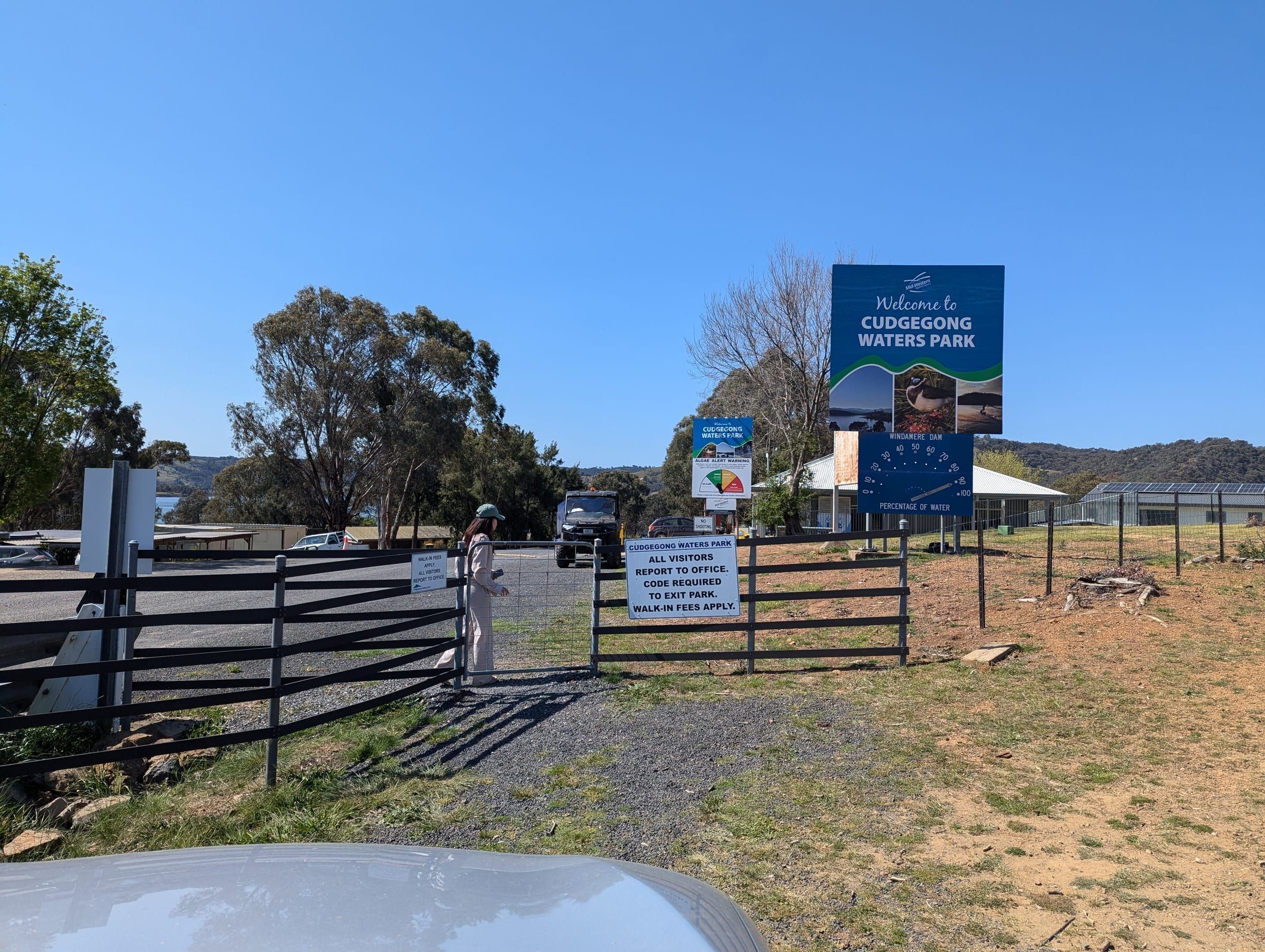 The entrance sign and gate for Cudgegong Waters Park, with a visitor walking through